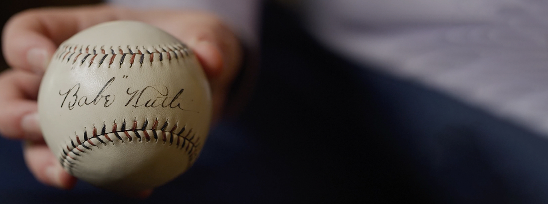 Close-up of a white baseball with 'Babe Ruth' signature.