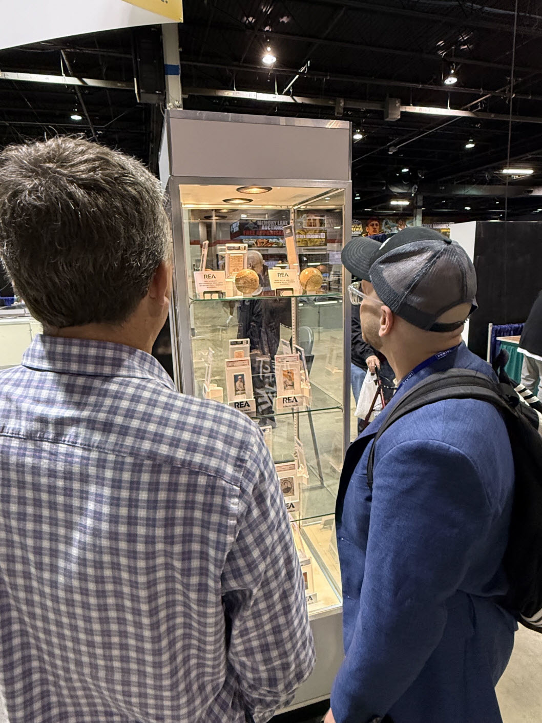 Collectors viewing the Mathewson-McGraw autographed baseball at REA’s booth inside the National.