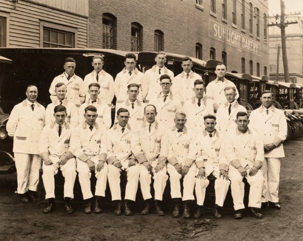 Employees of Morehouse/Sunlight Bakery pose for a photo with delivery trucks in the background. -Photo courtesy Lawrence History Center, Lawrence, MA.